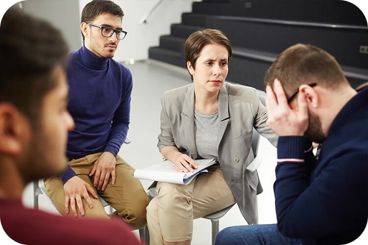 Psychologist from Mindsight Clinic conducting cognitive behavior therapy on a group of patients
