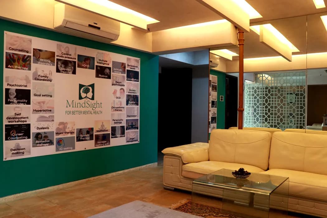 A waiting area at Mindsight Clinic, Malad West, Mumbai, with a cream leather sofa beside a green wall